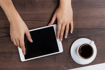 women hands with tablet computer and coffee on table