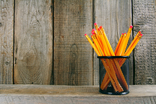 Pencils on a wooden shelf.