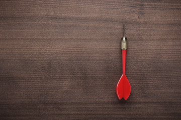 red dart on wooden background