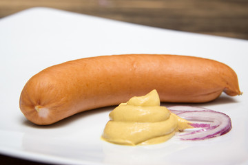 Eine Bockwurst mit Senf auf Teller