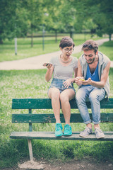 couple of friends young  man and woman using smartphone