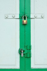 Old Brass Padlock on Wooden Green Gate