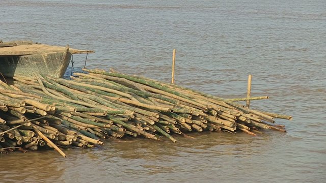 Stack of bamboo poles at the bow of a towing barge