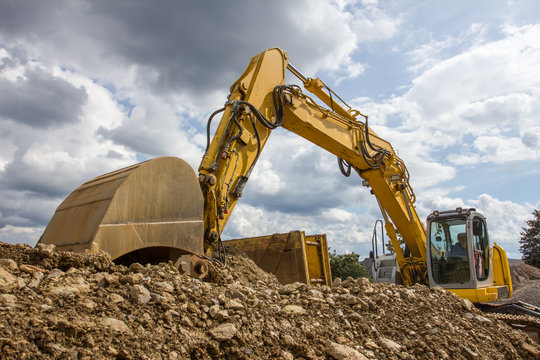 excavator in front of a cloudy sky