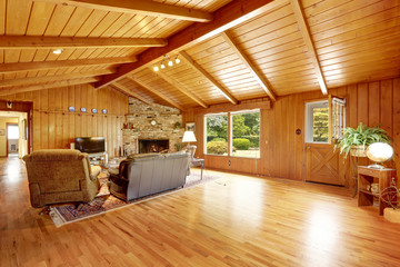 Log cabin house interior. Living room with fireplace and leather