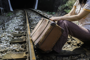 Woman and vintage suitcase on railway road