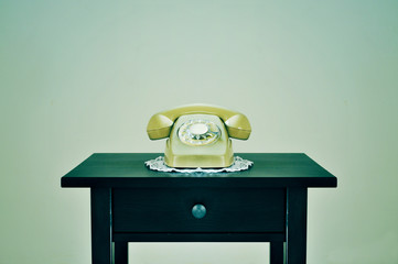 old rotary dial telephone on a table, with a retro effect