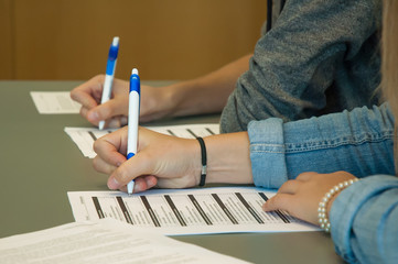 Close up of the hands of two people holding a pen, making a test