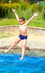 Fototapeta na wymiar Boy jumping into a swimming pool