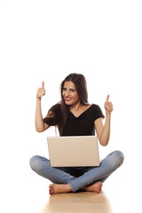 happy girl working on laptop, and showing thumbs up