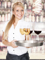 Pretty lady waitress with four glasses of wine