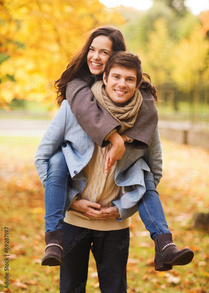 Poster smiling couple hugging in autumn park