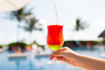 close-up of hand holding glass with cocktail