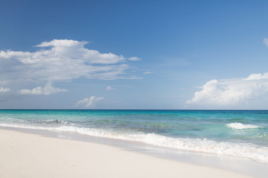 blue sea or ocean, white sand and sky with clouds