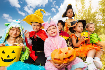 Halloween kids in beautiful costumes sitting