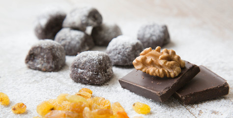 two pieces of black chocolate and a wallnut on it.