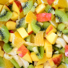 Top view of a fresh fruit salad with bananas kiwi orange and pea