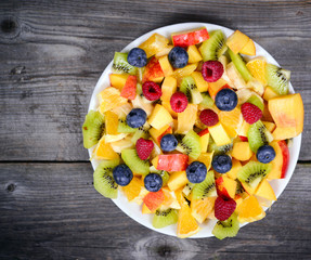 Top view of a fresh fruit salad with bananas kiwi orange blueber