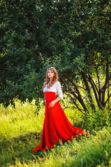 Obraz na płótnie Canvas woman in red skirt standing under the tree