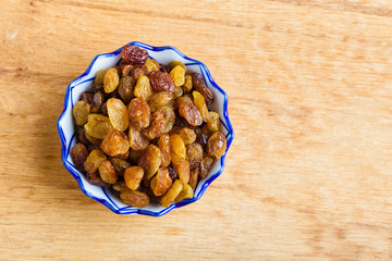 Diet healthy food. Raisin in bowl on wooden background