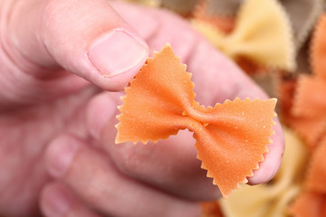 Pasta farfalle in the fingers
