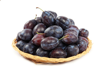 Fresh plums in a wooden basket.
