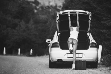 womanl with the suitcase near the car.