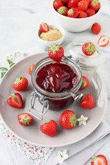 Homemade delicious strawberry jam on a light background.