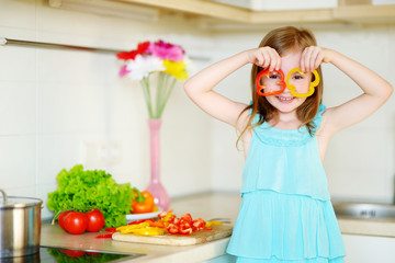 Little girl helping her mother in a kitchen