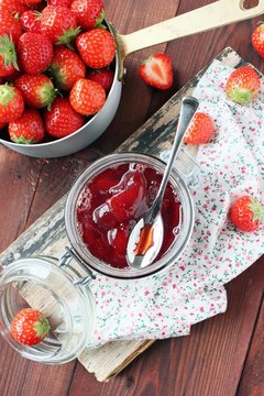 Homemade delicious strawberry jam on a rustic wooden table
