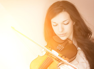Portrait of a young female playing the violin. With sunshine. © Vladimir Arndt