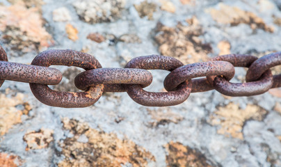 Heavy Rusty Chain Over Stone Wall