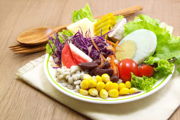 Salad and wood spoon, fork on cloth
