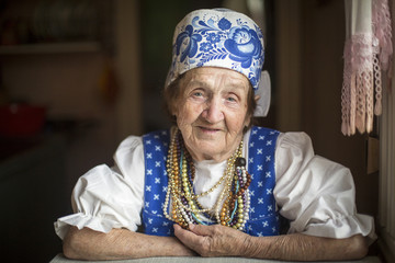 Portrait of elderly woman in ethnic clothes in his house.