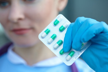 female doctor holding medicine capsules