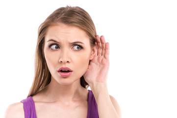 Woman listening with her hand  over white background.