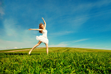 Woman jumping. Young beautiful girl jumping in  field on the gra