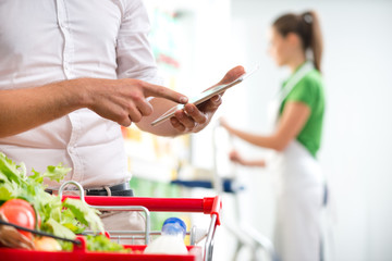 Customer with tablet at supermarket