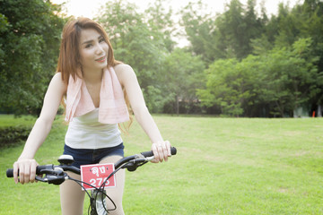 Woman riding an exercise bike in the park.