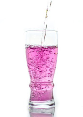 Pink water splashing from glass