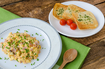 Scrambled eggs with chive and bacon, toast with herbs
