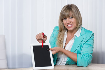 Frau zeigt mit einem Stift auf ein Tablet