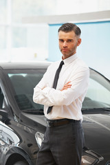 Salesman Stands Near Brand New Car. Car Showroom