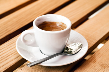 White espresso cup standing on the wooden table