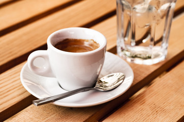 White espresso cup and glass of cold water