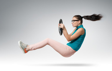 Young beautiful girl driver in glasses with a wheel
