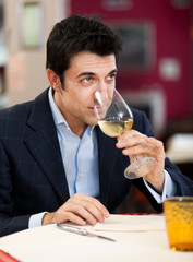 Handsome man drinking a glass of wine