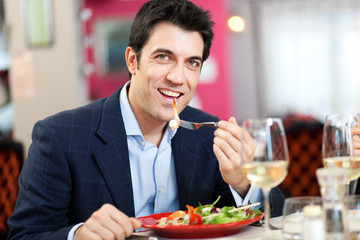 Handsome man eating at the restaurant