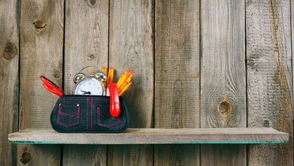 School tools in a case. On wooden background.