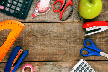 Back to school. School tools around. Wooden background.